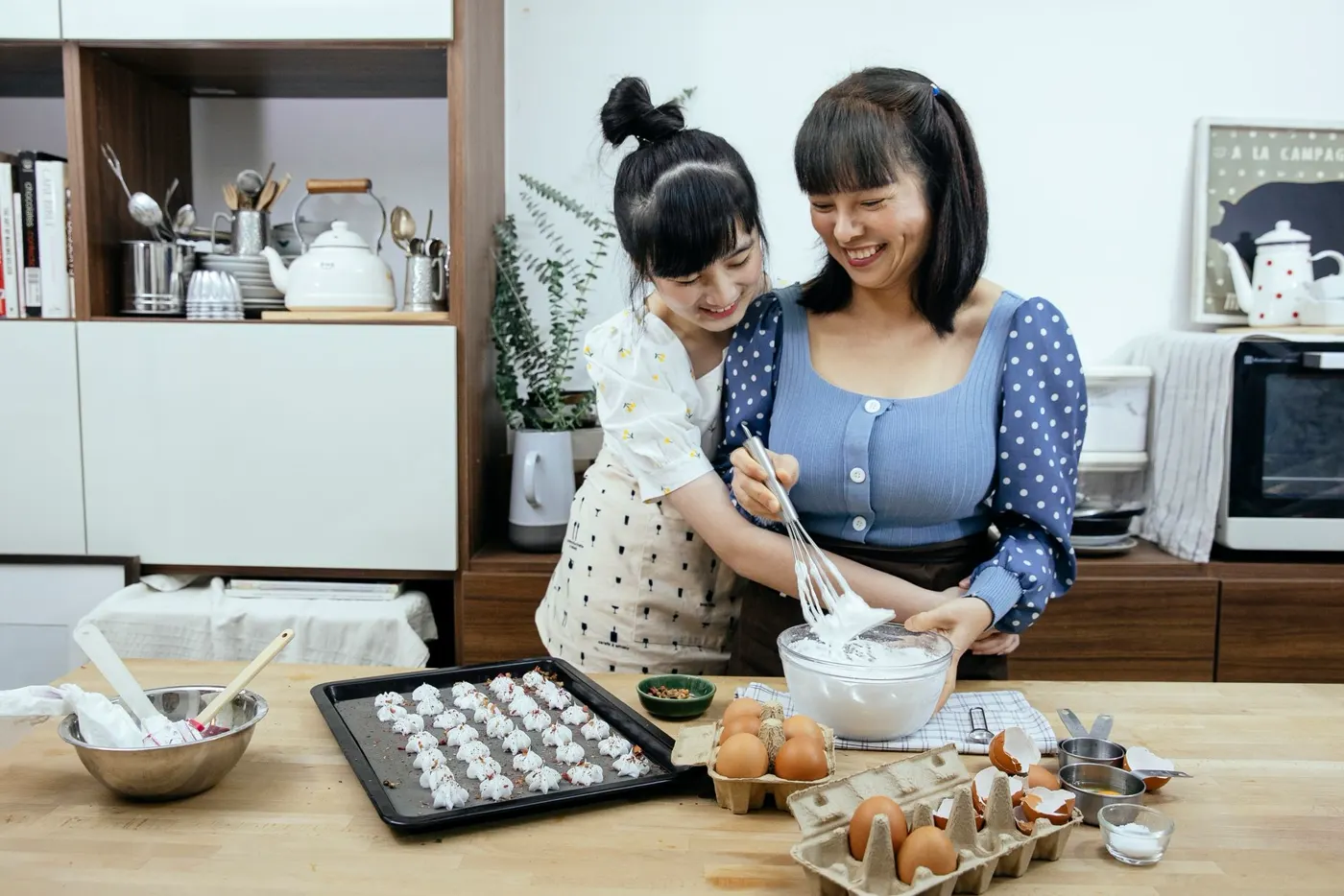 A parent and child cooking together in the kitchen