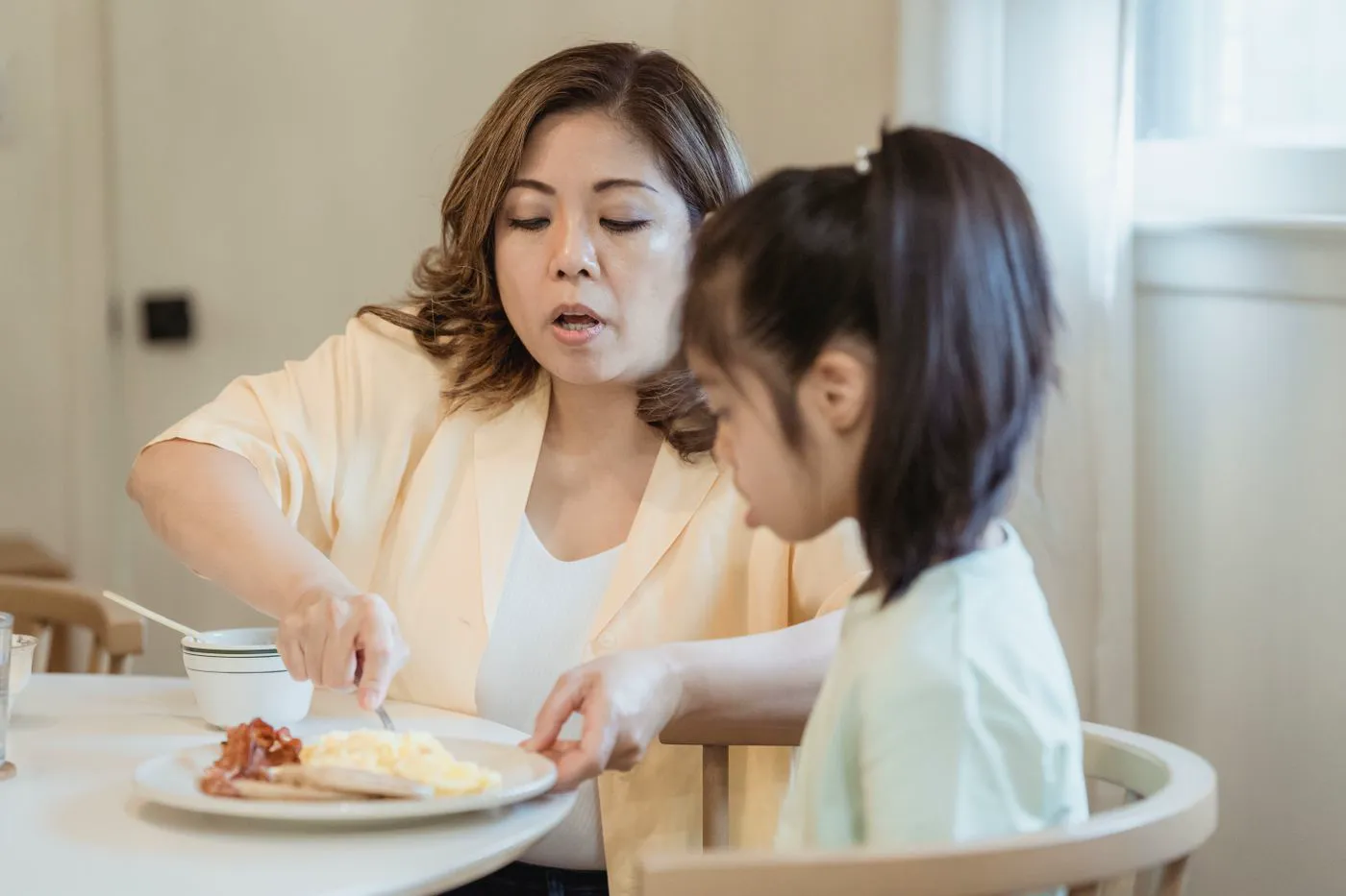 A parent and child having breakfast together at home